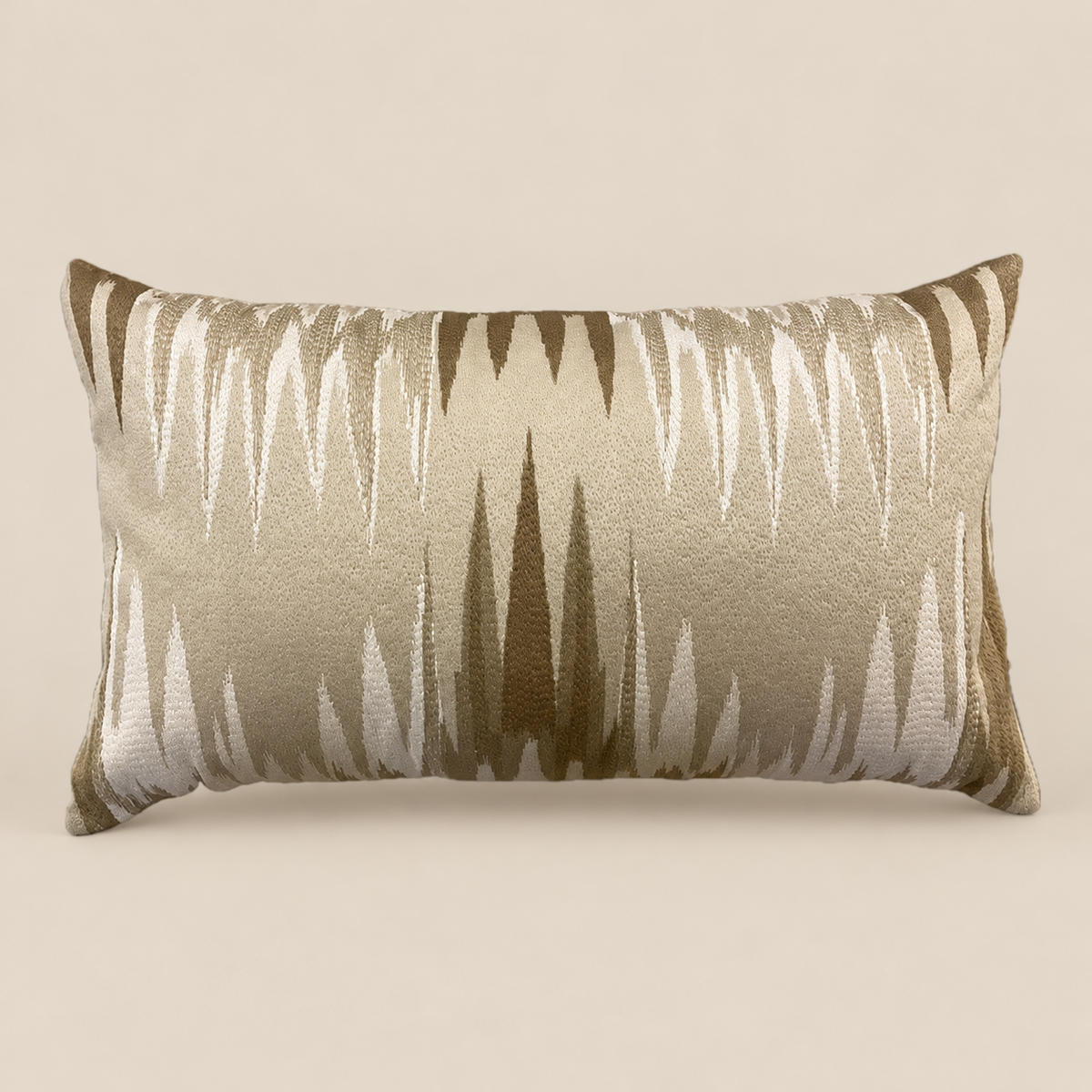 Kissen ATHENA Beige und Bronze vor beigem Hintergrund
