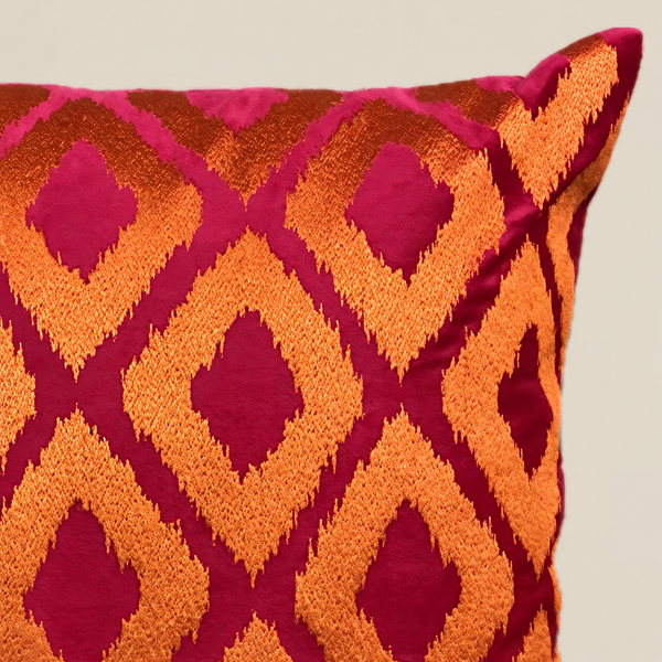 Stoffdetail des Kissens ELIORA Fuchsia und Orange vor beigem Hintergrund