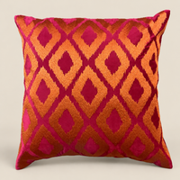 Kissen ELIORA Fuchsia mit orangefarbenem Muster vor beigem Hintergrund