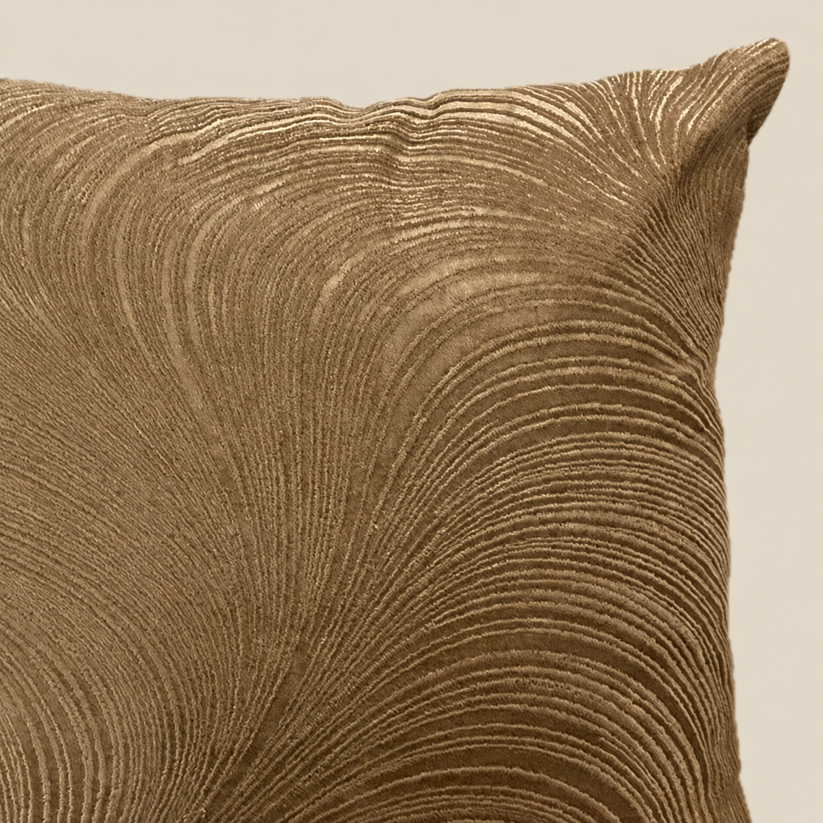 Stoffdetail Kissen ELOISE Bronze vor beigem Hintergrund