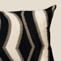 Kissen LAYLA Creme/Schwarz 60 × 35 cm – Stoffdetail vor beigem Hintergrund
