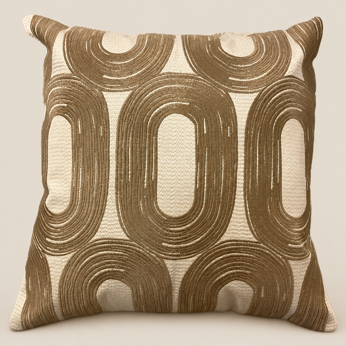 Kissen SAMIRA Beige/Bronze vor beigem Hintergrund