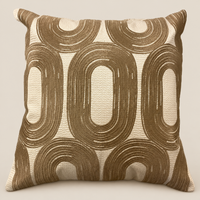 Kissen SAMIRA Beige/Bronze vor beigem Hintergrund