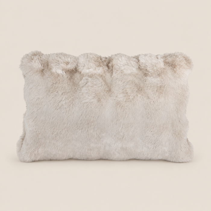 Kunstfellkissen LUCI Beige 50 × 35 cm vor warmem beigem Hintergrund