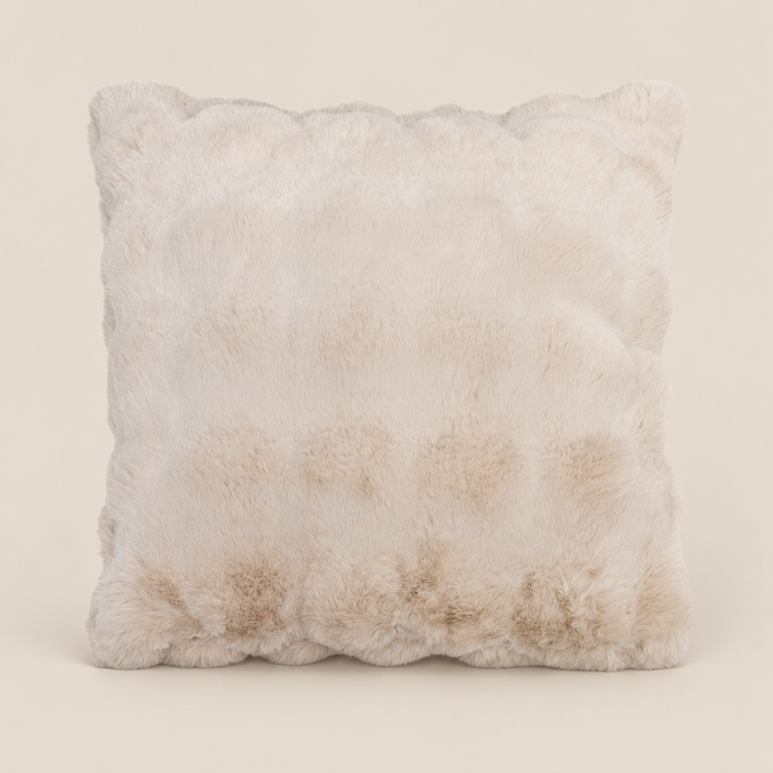 Kunstfellkissen LUCI Beige 50 × 50 cm vor warmem beigem Hintergrund