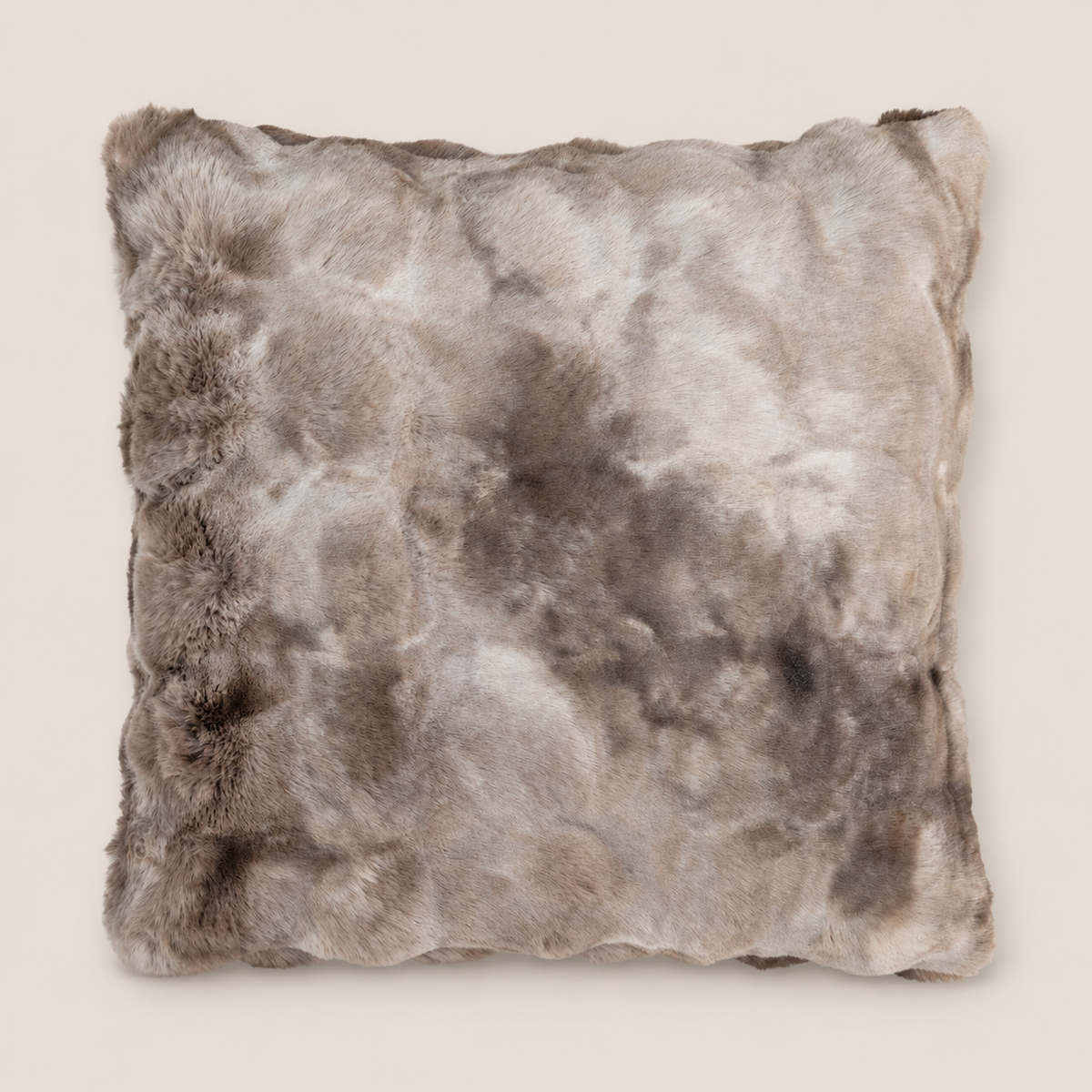 Kunstfellkissen LUCI Mocha Macchiato 50 × 50 cm auf warmem beigem Hintergrund