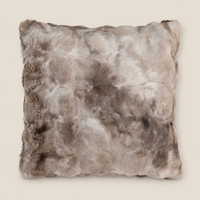 Kunstfellkissen LUCI Mocha Macchiato 50 × 50 cm auf warmem beigem Hintergrund