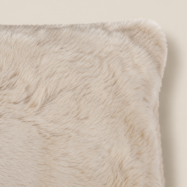 SUSAN Kunstfellkissen Beige 50 × 35 cm – Nahaufnahme auf beigem Hintergrund